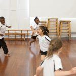 Children taking part in a warm-up in a real PE lesson